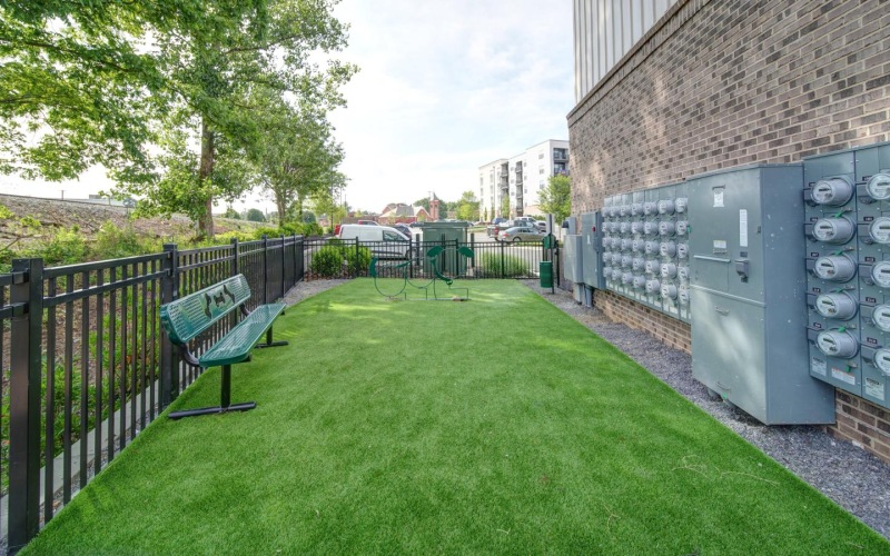 a park with benches and a brick wall