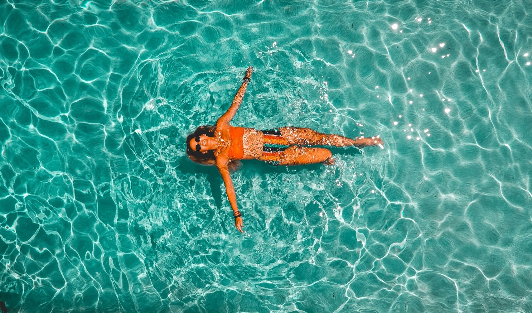 Relax and unwind poolside a woman floating in the pool